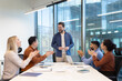 © Liubomir - A diverse business team engages in a professional meeting, showing appreciation and collaboration.