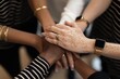 © Gordana - A group of diverse hands coming together in a show of unity and teamwork with a warm and friendly atmosphere