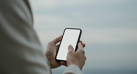Person using smartphone with blank white screen outdoors, mobile device mockup for app presentation and digital marketing campaigns