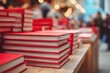 © VolumeThings - Red covered books arranged on a wooden table at a book fair highlighting publishing and reader engagement