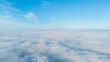 © tai - Aerial perspective showcasing fluffy white clouds floating under a clear blue sky, creating a serene natural atmosphere.