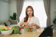 © WMSTUDIO - Young woman preparing fresh salad in modern kitchen, enjoying healthy lifestyle, surrounded by vibrant vegetables and cooking tools