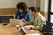 © Wavebreak Media - Collaborating diverse coworkers leaning over table in conference room, with laptop and charts