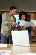© Wavebreak Media - Diverse colleagues pointing at tablet and reviewing printed charts in modern office, with laptop