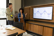 © Wavebreak Media - Discussing Diverse coworkers presenting timeline on screen in office conference room, with laptop