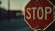 © quietmind_art - Weathered outdoor stop sign against blurred urban background at sunset.