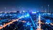 © คงเดช ผาผง - Night aerial cityscape shows glowing data connections forming a vibrant network across urban buildings, symbolizing modern technology and communication, worldwide.