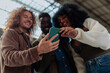 © bernardbodo - Group of young designers using smart phone app in modern office