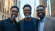 © sommersby - Vibrant portrait of three strikingly similar African American men, wearing glasses and salt-and-pepper beards, smiling confidently in modern business casual attire against urban backdrop.