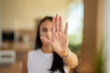 © Dexon Dee - Close up of woman showing stop gesture with open palm hand indoors.