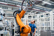 © BusinessClass by W61 - Two technicians examining industrial robot in a factory