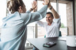 © BusinessClass by W61 - Smiling mature businessman giving high-five to colleague at desk in office