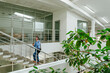 © BusinessClass by W61 - Businessman moving up stairs in modern green office