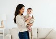 © David - Mother holding baby in modern living room lifestyle photography cozy home environment warm and loving connection