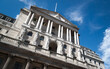 The Bank of England, City of London, UK. A low-angle view of the historic Bank of England building set against a clear blue sky. 