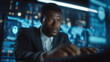 © Natali IQstock - Side view of a focused Black African American IT specialist working intently, immersed in futuristic workspace, surrounded by glowing holographic displays of cybersecurity threats,