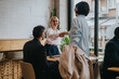© qunica.com - Professional colleagues engage in a discussion at a stylish co working space, fostering collaboration and networking. A scene of teamwork and communication in a dynamic, modern environment.