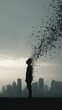 © najzril - Silhouette figure disintegrating into particles against a cityscape and cloudy sky