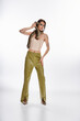 © LIGHTFIELD STUDIOS - Young beautiful woman gracefully poses with a snake in a stylish outfit under bright lights