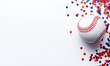 © Momentum - A baseball rests on white, scattered with red and blue confetti. The crisp, bright image highlights the sphere's stitching and its association with celebratory elements