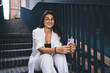 © BullRun - Modern young woman seated outdoors with smartphone, capturing candid moment of mobile interaction and friendly expression in digital communication.