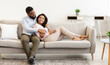 © Prostock-studio - Happy Loving Family. Beautiful african american couple spending weekend together, resting on the couch indoors at home in living room, relaxing and enjoying the company of each other, hugging