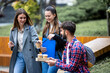 © Mediteraneo - Students Laughing with Books and Coffee on College Campus
