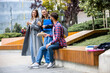 © Mediteraneo - Students Laughing with Books and Coffee on College Campus