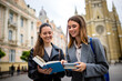 © Mediteraneo - Two Female Students with Books on College Campus