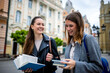 © Mediteraneo - Two Female Students with Books on College Campus