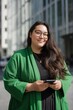 © Andrii Zastrozhnov - Asian young female with smartphone in green coat outside modern building