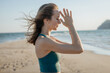 © YuliaSmyt - Close-up portraits of a young woman meditating on the beach with hands in prayer position. Calm, mindfulness and inner balance in a peaceful outdoor setting