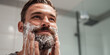 © Andres Mejia - Handsome man washing his beard in the bathroom