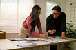 © PaeGAG - Asian business people analyzing charts and graphs, discussing financial strategy in office meeting