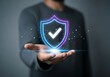 © SamiaAkter - Man holding a glowing neon shield with a checkmark, representing security and verification