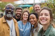 © Pavel - Diverse group of healthcare professionals and workers smiling together outdoors at a community event in a vibrant garden setting during the daytime