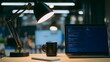 © han - A developer's workstation with an empty notebook and coffee mug under soft desk lamp lighting.