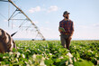 © Drazen - Happy farmer with digital tablet walking through the crops.