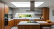 © Riyono - Sophisticated modern kitchen with sleek wood cabinetry and skylight creating bright interior