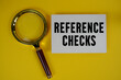 © may1985 - Reference Checks text written on paper with magnifying glass