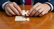 © Inspire Shots Hub - Close-up of hands placing wooden puzzle piece, on wood table, symbolizing connection, problem-solving, teamwork, and collaboration in business