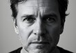 © Dahab - Dramatic high-contrast black and white studio portrait of a serious middle-aged man with a thoughtful and intense gaze.