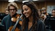© Николай Срибяник - Beautiful young woman with bright smile during orchestra rehearsal. Musicians with violins in background creating warm, artistic atmosphere in concert hall.