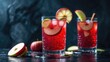 © Sona - Vibrant red beverage in glasses with apple slices, accompanied by whole and halved apples on a dark surface. Refreshing drink with fruit garnish.