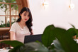 © snowing12 - Asian Young Woman Remote Work Laptop Computer Modern Cafe Digital Nomad Professional Focused Online Workspace Productivity Lifestyle