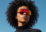 Bold Shades: A portrait features a striking individual wearing bold, vibrant sport shades against a clear blue sky, embodying confidence and style. 