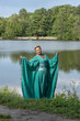 © Светлана  - Beautiful brunette girl in a turquoise long dress in nature by the lake. Siren