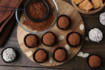 Wall Mural - delicious homemade candies with cocoa powder and coconut flakes on wooden table, flat lay