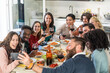 © Davide Zanin - Group of multicultural friends toasting with red wine while taking a selfie during a pasta dinner. Concept of friendship, celebration, Italian cuisine and joyful moments shared together.