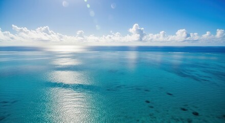 Wall Mural - Ocean view with fluffy clouds and sun reflecting on turquoise water